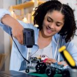 Young woman using tool on electronics