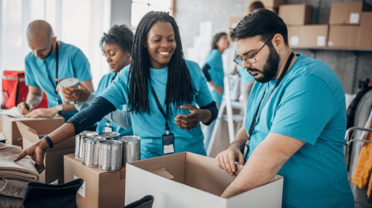 A man and a woman at a can food drive filling boxes